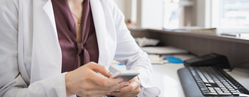 Femme portant un sarrau consultant un téléphone mobile